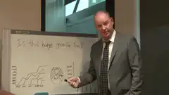 Man in suit laughs at whiteboard
