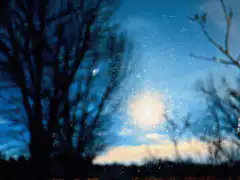 Snow falling in front of a blue sky