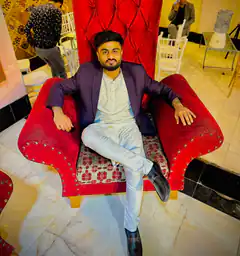 Man in purple blazer on red chair
