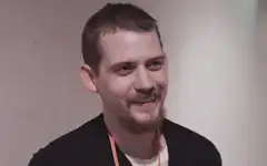 Man smiling with orange lanyard