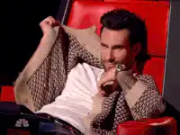 Adam Levine pulls sweater over face