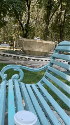 blue park bench with coffee cup