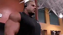 Muscular man flexing bicep in gym