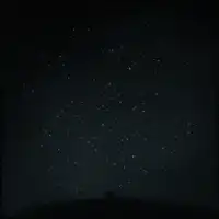 Silhouette under starry night sky