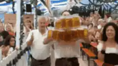 Waiter carrying a huge tower of beer mugs