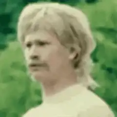 blonde man with mustache looking around