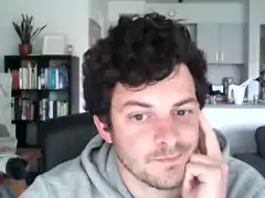 Man with curly hair resting chin on hand