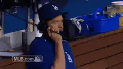 Baseball player hangs up phone shrugging