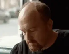 Man rubs head then smirks