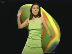 Woman in green dress dancing with rainbow blob
