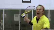 Man in yellow shirt hits cat with tennis racket