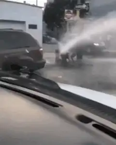 man playing in fire hydrant water