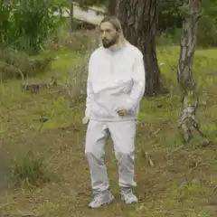 man in white tracksuit dancing in woods
