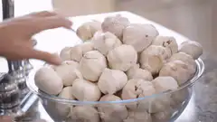 Hand picking garlic from a bowl