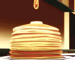 Honey pouring on pancakes