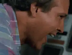 Chevy Chase sweating and laughing