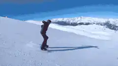 Snowboarder carving down a snowy slope