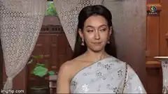 Woman in white sari smirking