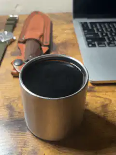 Metal cup on wooden desk