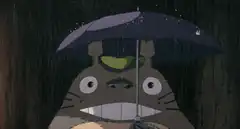 Totoro holding an umbrella in the rain