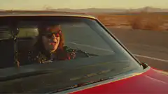 Woman singing in car desert