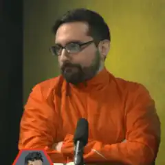 Man in orange shirt gives thumbs up