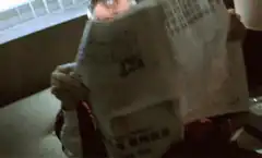 Man peeking over newspaper