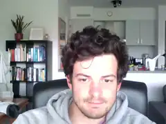 Man with curly hair looking at camera
