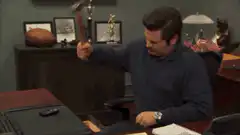 Ron Swanson smashing a stapler with a hammer
