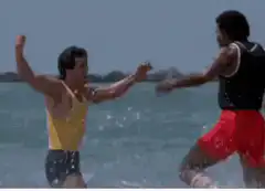 Two men fighting in the ocean then hugging