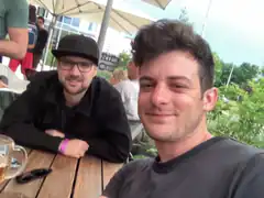 Two men smiling at outdoor cafe