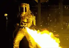 Person in gold suit using flamethrower