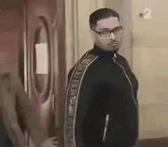 Man in tracksuit turns and stares intensely