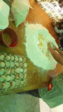 Hands mixing flour and eggs on a wooden table