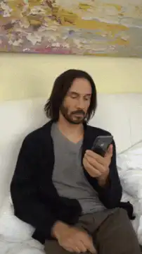 Keanu Reeves laughing at phone