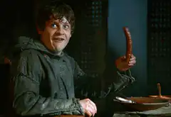 Ramsay Bolton holding a sausage