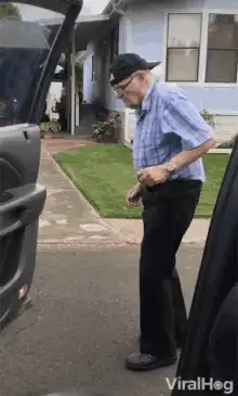 Old man dancing by car