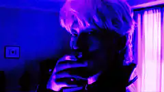 Man exhaling smoke in blue light