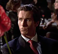 Christian Bale smirking and raising eyebrows