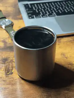 Steam rising from a metal cup of coffee