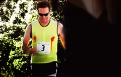 Man running with blood on shirt