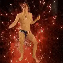 Man in American flag speedos dancing with fireworks