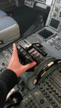 Hand adjusting throttle levers in cockpit