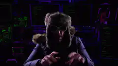 Hacker in fur hat typing with skull screens