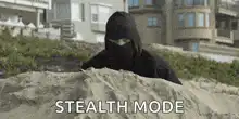 Person in stealth suit on beach