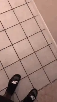 person tying shoelace on tiled floor