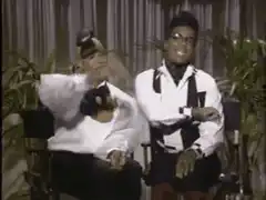Two men in white shirts dancing in chairs