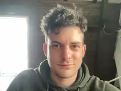 Man in green hoodie looking at camera
