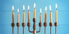 Nine lit candles on a menorah