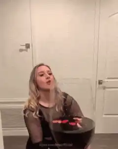 Woman drinks from giant wine glass